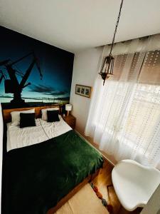 a bedroom with a bed and a white chair at Gold Box Apartament in Gdańsk