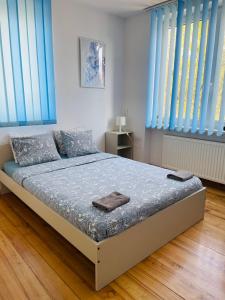Pokoje Slawin في لوبلين: غرفة نوم بسرير والستائر الزرقاء والملايات الزرقاء