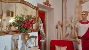 um quarto com um manequim e um vaso com flores vermelhas em Império Romano Guest House em Beja