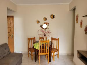 a dining room with a table and chairs and a couch at Apartamento 2 qtos Praia de Santos in Santos