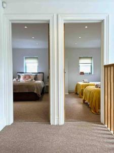 pokój z 3 łóżkami i żółtą pościelą w obiekcie The Gables - Spacious house, picturesque views & free parking w mieście Bath