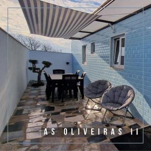 d'une terrasse avec une table et des chaises sur un mur bleu. dans l'établissement Casa de Férias_As Oliveiras II, à Espinho