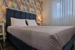 1 dormitorio con 1 cama grande y cabecero azul en Casa de Férias_As Oliveiras II en Espinho
