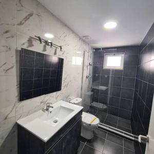 Casa de Férias_As Oliveiras II في إسبينهو: حمام أسود وبيض مع حوض ومرحاض