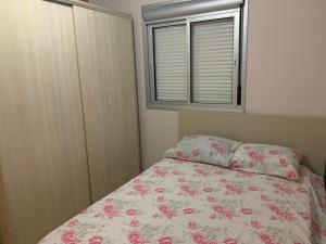 ein kleines Schlafzimmer mit einem Bett und einem Fenster in der Unterkunft Apartamento do Aconchego in Bento Gonçalves