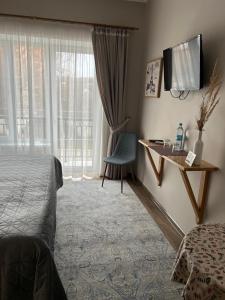 ein Hotelzimmer mit einem Bett, einem Schreibtisch und einem Fenster in der Unterkunft Tamerlan in Chmelnyzkyj