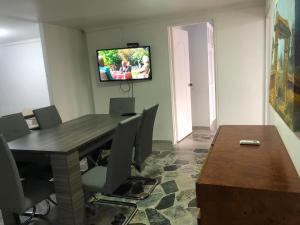 comedor con mesa y TV en la pared en Apartamento cómodo,grande,céntrico,bien ubicado Apto 203, en Medellín