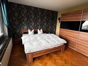 um quarto com uma cama e piso em madeira em Haus Panoramablick em Burg-Reuland