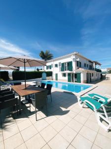 un patio con tavolo e sedie e una piscina di Good Vibes Villa ad Aljezur