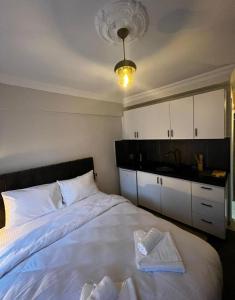 - une chambre avec un grand lit blanc et des serviettes dans l'établissement Mr Miller Suites, à Istanbul