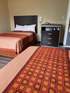 ein Hotelzimmer mit 2 Betten und einer Kommode in der Unterkunft Savannah Motel in Savannah