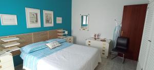 a bedroom with a bed and a desk and a chair at Holiday Home Tropicana in Mascali