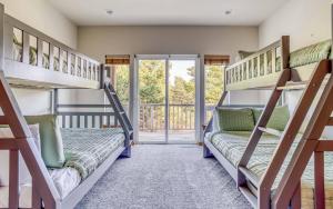 two bunk beds in a room with a balcony at Pelicans Watch - Meredith Lodging in Pacific City