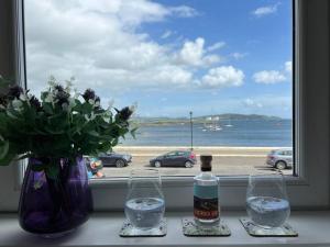 a window with two wine glasses and a bottle of water at Fantastic 3 bedroom holiday home in Millport