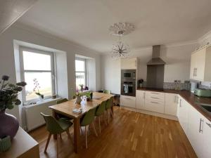a kitchen with a wooden table and green chairs at Fantastic 3 bedroom holiday home in Millport