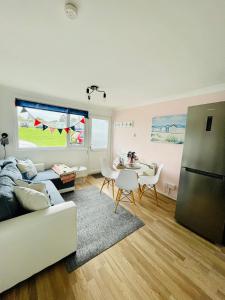 een woonkamer met een bank en een tafel bij “BLISS ON THE BAY ” chalet in Sandown Bay Holiday Park in Sandown