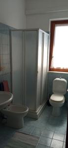 a bathroom with a toilet and a shower and a sink at Holiday Home Tropicana in Mascali