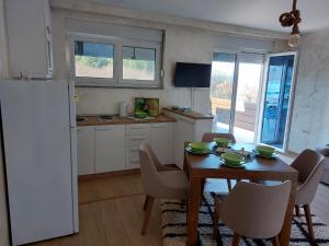 uma cozinha e sala de jantar com uma mesa e um frigorífico em Goran apartmani em Sokobanja