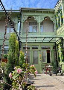 a green house with a table in front of it at Artisan Boutique Hotel & Gallery in Tbilisi City