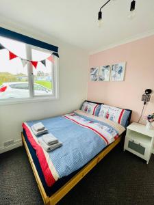 Schlafzimmer mit einem Bett und einem Fenster in der Unterkunft “BLISS ON THE BAY ” chalet in Sandown Bay Holiday Park in Sandown