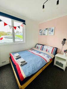 a bedroom with a bed and a window at “BLISS ON THE BAY ” chalet in Sandown Bay Holiday Park in Sandown