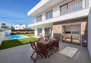 a patio with a table and chairs in front of a house at Aroeira Villa w/ Pool near Beach, By TimeCooler in Aroeira