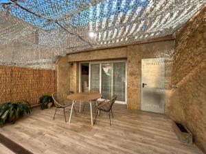 een kamer met een tafel en stoelen en een plafond met verlichting bij Costa Brava Apartments in Palafrugell