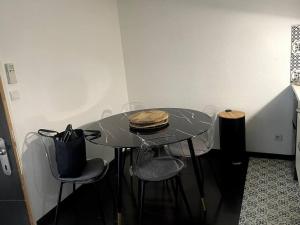 una mesa negra con sillas y un pastel. en Le Chic, en Lourdes 3 fotos más