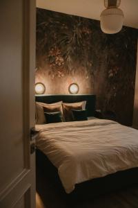 - une chambre avec un lit et deux lumières sur le mur dans l'établissement No.8 Studio, à Sibiu