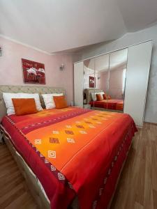een slaapkamer met een groot bed en een oranje deken bij Villa Mare Apartments in Tivat