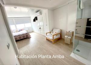 ein Schlafzimmer mit einem Bett und einem Stuhl in der Unterkunft Bungalow soleado a 100 metros de La Playa in La Mata