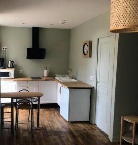 una cucina con tavolo, tavolo e porta di Logement à Brive avec terrasse et climatisation - près de la gare et du centre-ville - Wifi et Stationnement gratuit a Brive-la-Gaillarde