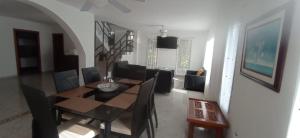 comedor y sala de estar con mesa y sillas en Villa Las Marias, en Santa Verónica