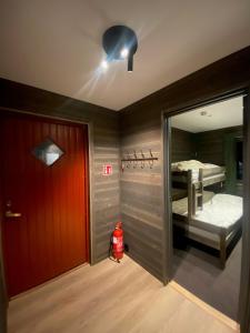 um quarto com uma porta vermelha e um quarto com uma cama em Brobygget Mølla 101 em Kyrkjebøen