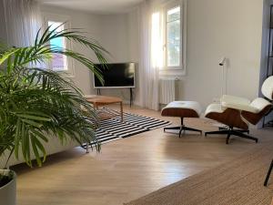 ein Wohnzimmer mit einem Flachbild-TV und einer Topfpflanze in der Unterkunft Burgos Señorial by Exclusive Burgos Apartments in Burgos