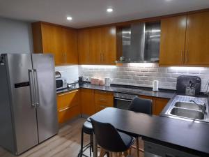 a kitchen with wooden cabinets and a stainless steel refrigerator at Casa Pirosa2 in Aveiro
