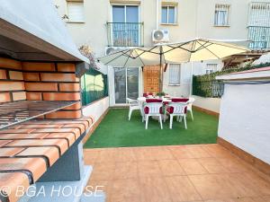 een patio met een tafel en stoelen en een parasol bij Bga Rentals Aini in Cambrils