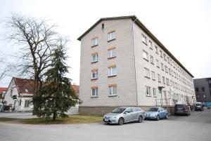 two cars parked in front of a large building at City Apartment in Kuressaare