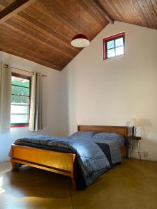 um quarto com uma cama grande num quarto em Pousada Soyndara em São Thomé das Letras