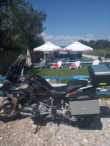 ein schwarzes Motorrad, das vor einem Pool parkt in der Unterkunft Camping Danubius Tulcea in Tulcea