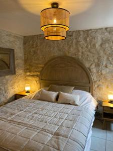 a bedroom with a large bed and a chandelier at La Magnanerie en Provence in Niozelles