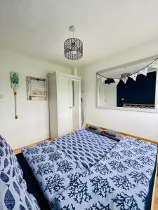 um quarto com uma cama azul e branca em “SEA HEAVEN “ chalet in Sandown Bay Holiday Park em Brading