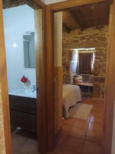 een badkamer met een bed en een wastafel in een kamer bij Casa do Xurés in Maus de Salas