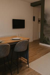 Cette chambre dispose d'une table avec deux chaises et d'une télévision à écran plat. dans l'établissement No.8 Studio, à Sibiu