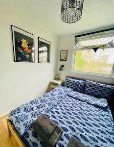 a bedroom with a bed with a blue comforter and a window at “SEA HEAVEN “ chalet in Sandown Bay Holiday Park in Brading