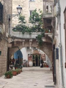 an alley with an archway in a building with plants at B&B Romeo in Bari