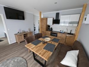 sala de estar con mesa de madera y cocina en Ferienwohnung Vogt, en Blankenburg