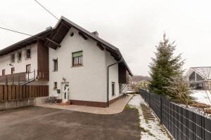 ein weißes Haus mit einem Zaun davor in der Unterkunft Vrtnarjeva hiša, The Gardener's Cottage in Radovljica
