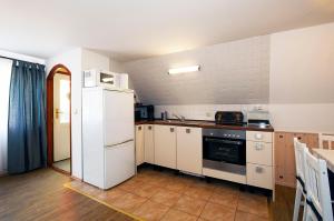 eine Küche mit einem weißen Kühlschrank und einem Herd in der Unterkunft Ferienhaus Katharina in Malschwitz