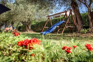 a playground with a slide and red flowers at Apartment Kozino 1 in Kožino